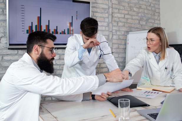 Worried researchers in white lab coats