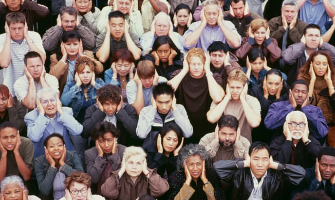 crowd of people covering their ears