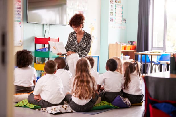 teacher reading to primary-age pupils