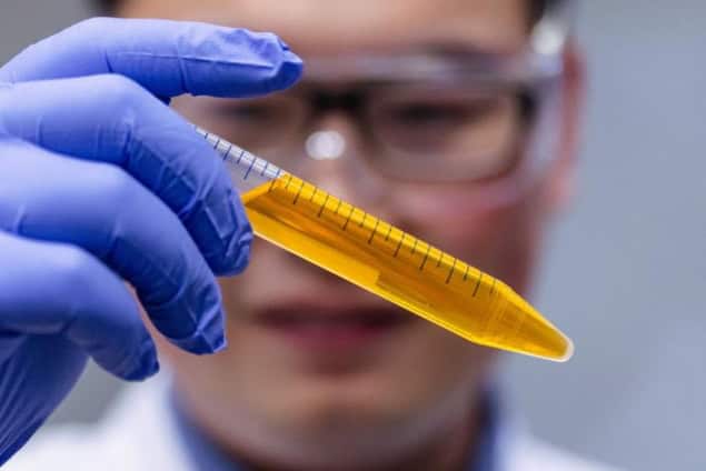 Zihao Ou holds a vial of the common yellow food dye tartrazine in solution