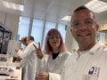 Students in white lab coats at a lab bench