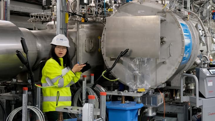 Jianqin Zhang with the beta elliptical cryomodule at the ESS superconducting linear accelerator