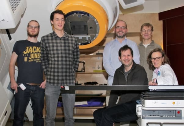 The researchers in front of the Novalis Tx treatment unit